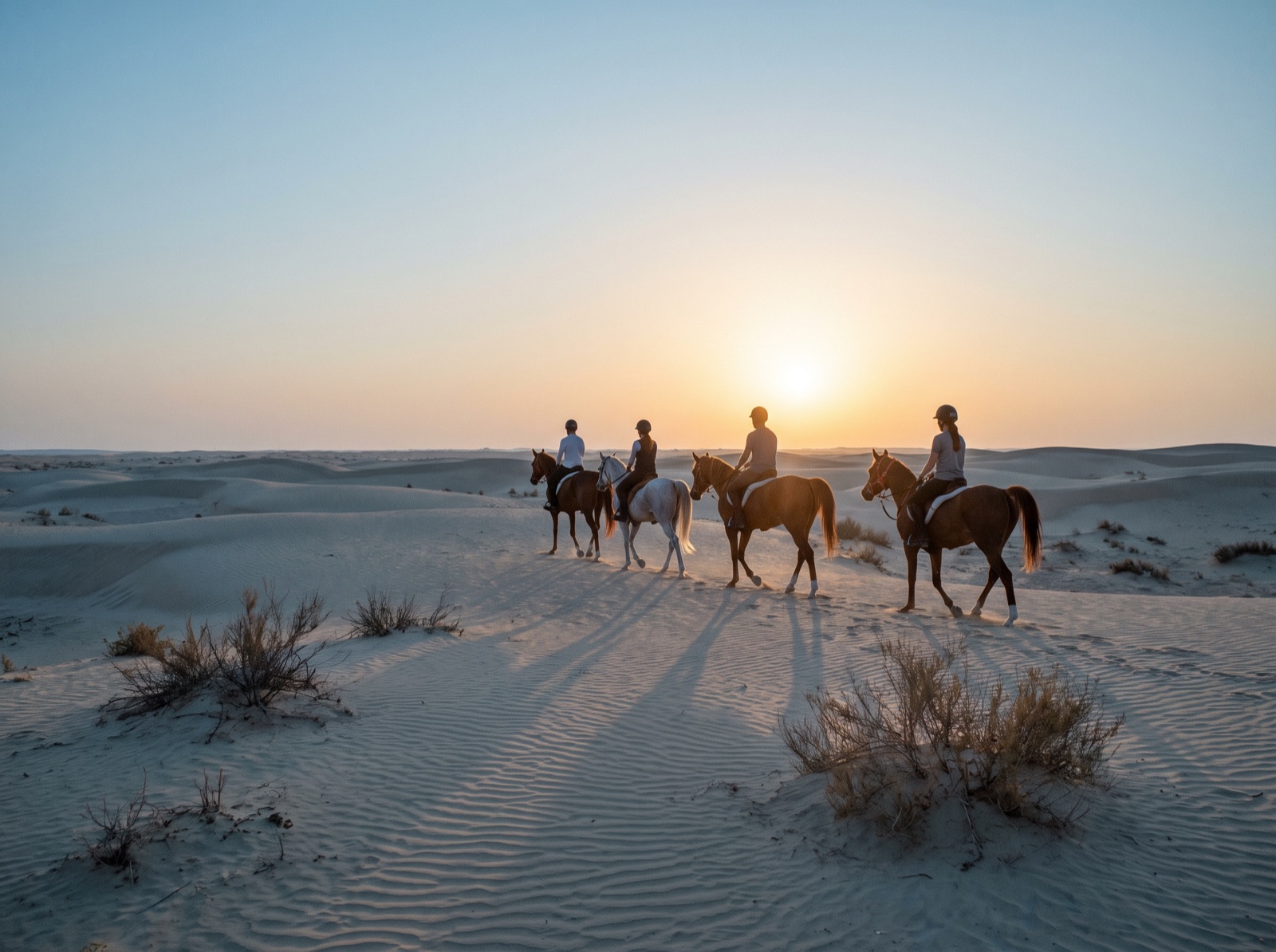 Riders crossing the dunes at first light